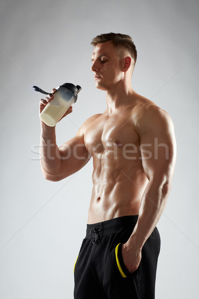 young man or bodybuilder with protein shake bottle Stock photo © dolgachov