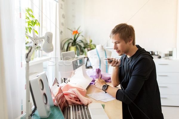 fashion designer with smartphone working at studio Stock photo © dolgachov