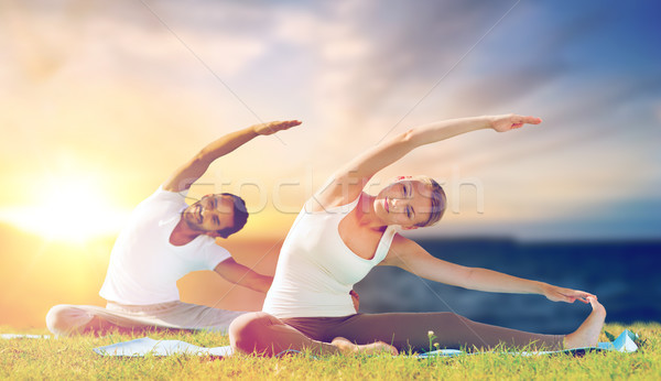couple making yoga exercises outdoors Stock photo © dolgachov