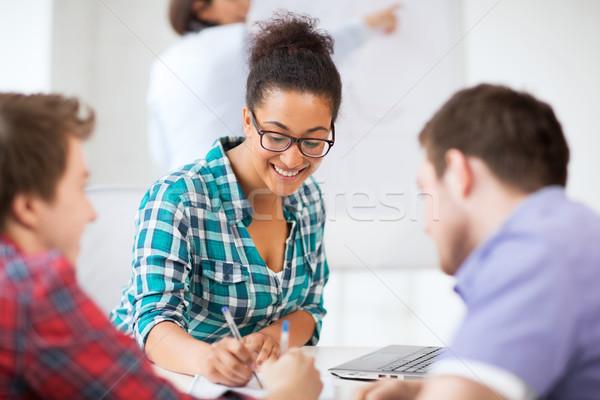 african student writing something in notebook Stock photo © dolgachov