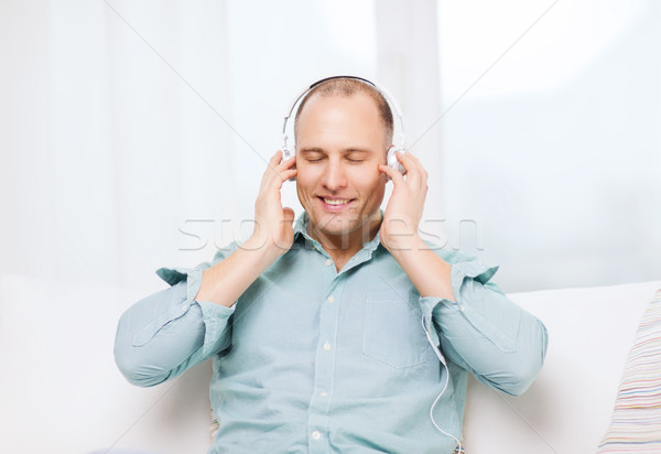 smiling man with headphones listening to music Stock photo © dolgachov