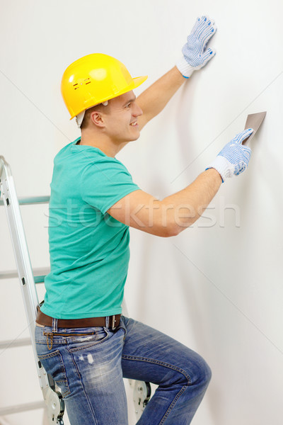 smiling man in helmet doing renovations at home Stock photo © dolgachov