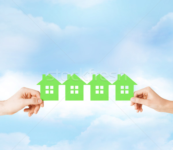 man and woman hands with many green paper houses Stock photo © dolgachov