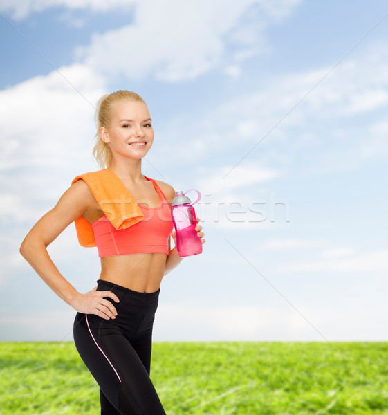 Souriant femme une bouteille d'eau serviette sport Photo stock © dolgachov