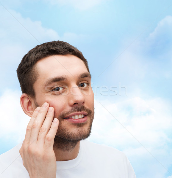 Stock photo: beautiful smiling man touching his face