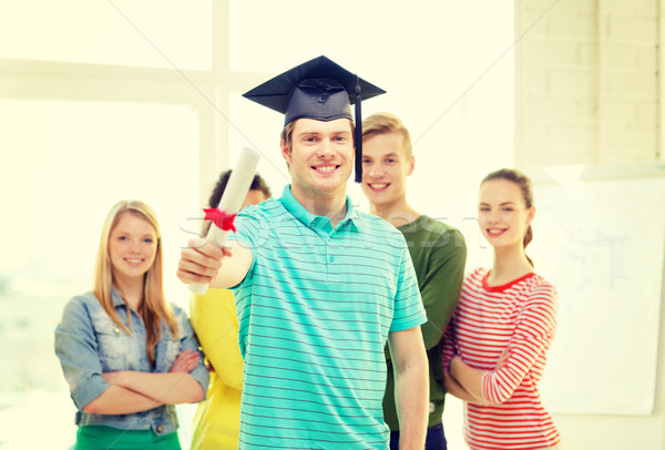 smiling male student with diploma and corner-cap Stock photo © dolgachov