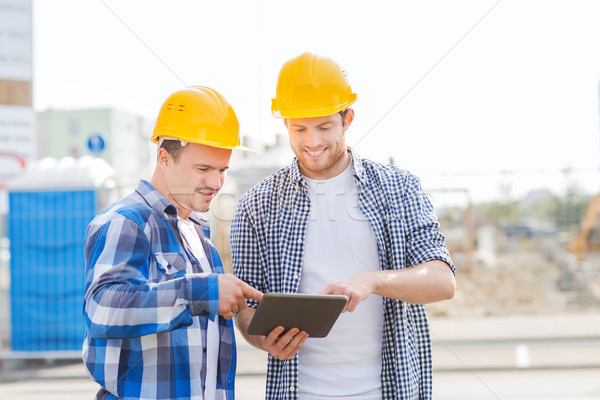 smiling builders in hardhats with tablet pc Stock photo © dolgachov