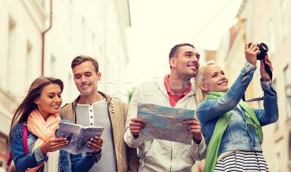 group of friends with city guide, map and camera Stock photo © dolgachov