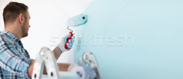 close up of male in gloves holding painting roller Stock photo © dolgachov