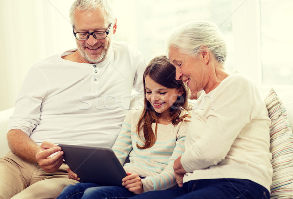 smiling family with tablet pc at home Stock photo © dolgachov