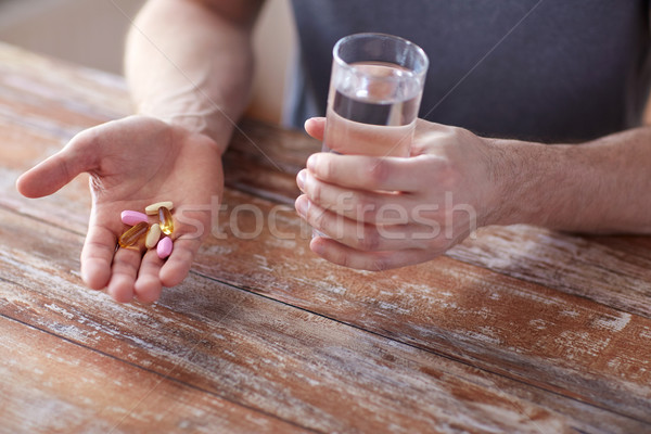 Masculino mãos pílulas água Foto stock © dolgachov