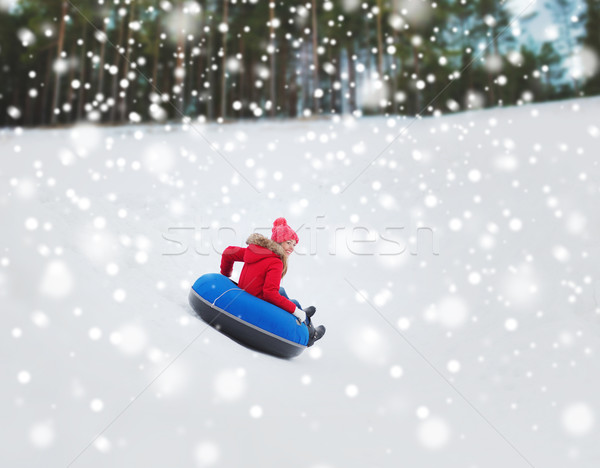 happy teenage girl sliding down on snow tube Stock photo © dolgachov