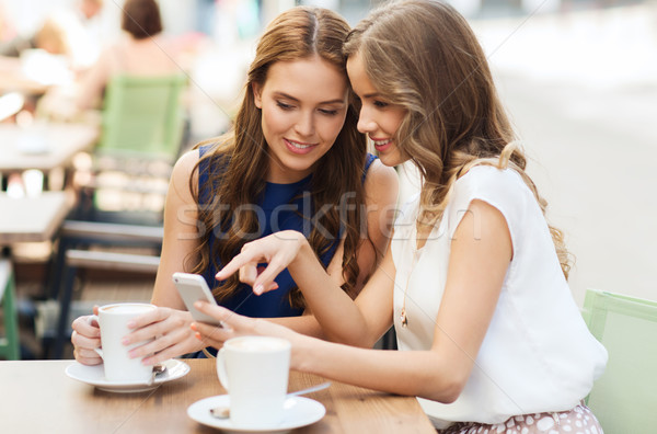 young women with smartphone and coffee at cafe Stock photo © dolgachov