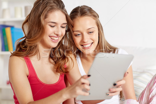 happy friends or teen girls with tablet pc at home Stock photo © dolgachov