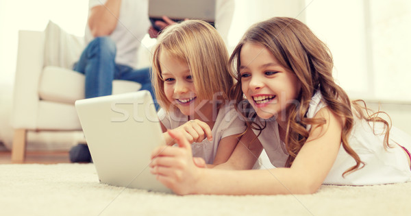 smiling sister with tablet pc and parents on back Stock photo © dolgachov