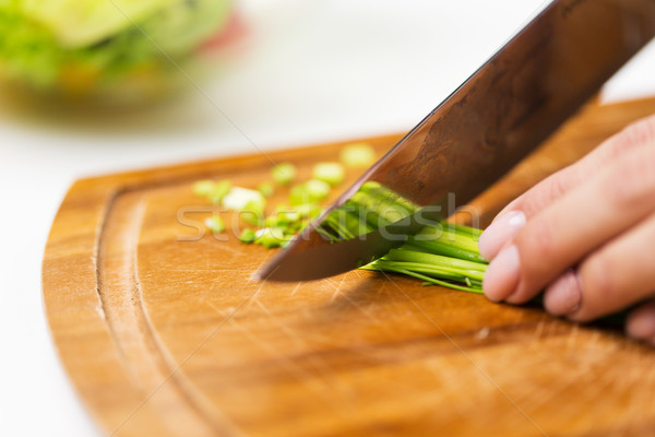 close up of woman chopping green onion with knife Stock photo © dolgachov