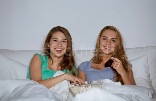 Fericit prietenii floricele de porumb vizionarea televizor acasă Imagine de stoc © dolgachov