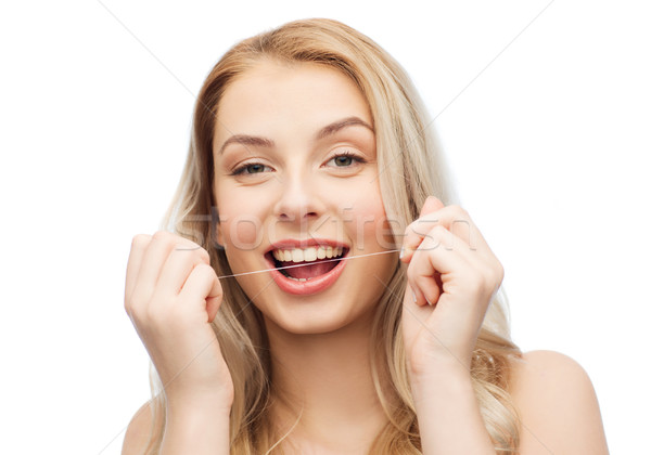 happy young woman with dental floss cleaning teeth Stock photo © dolgachov