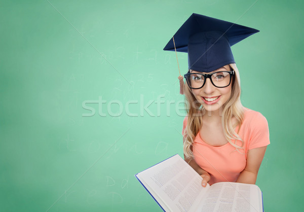 student woman in mortarboard with encyclopedia Stock photo © dolgachov