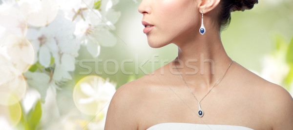 close up of woman with earring and pendant Stock photo © dolgachov