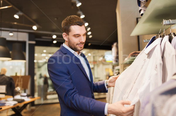 Boldog fiatalember választ ruházat ruházat bolt Stock fotó © dolgachov