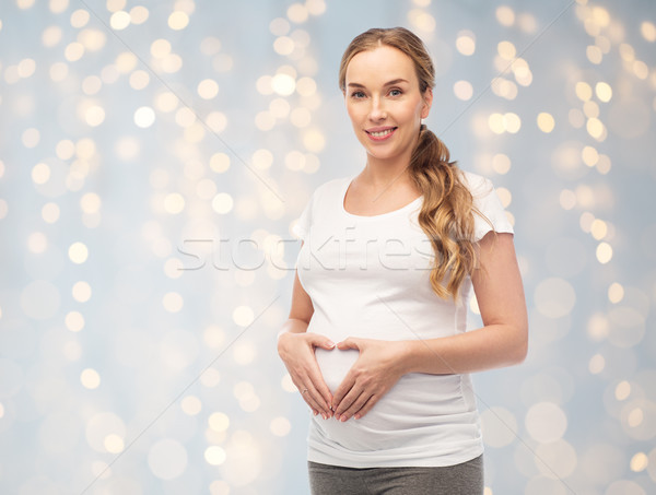 Felice donna incinta cuore gesto gravidanza Foto d'archivio © dolgachov