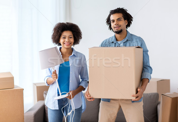 happy couple with stuff moving to new home Stock photo © dolgachov