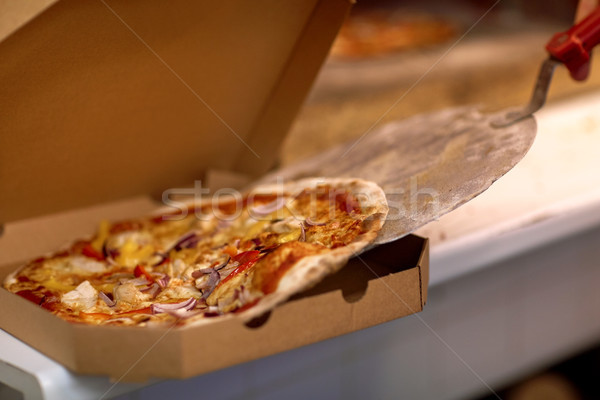 chef placing pizza from peel to box at pizzeria Stock photo © dolgachov