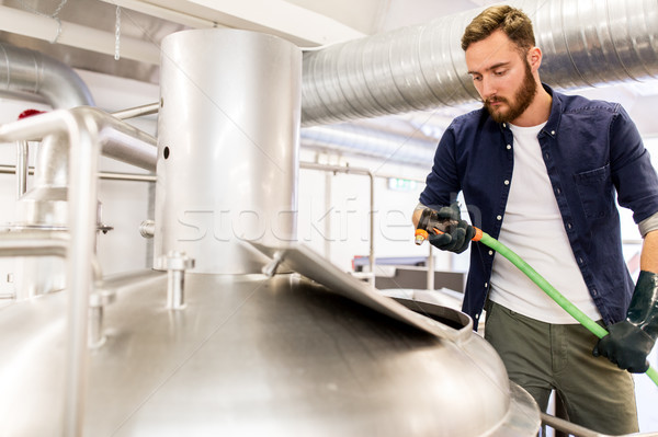 man with hose working at craft beer brewery kettle Stock photo © dolgachov