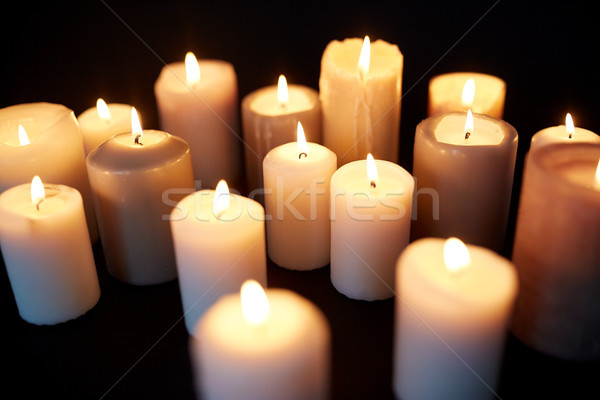 Stock photo: candles burning in darkness over black background