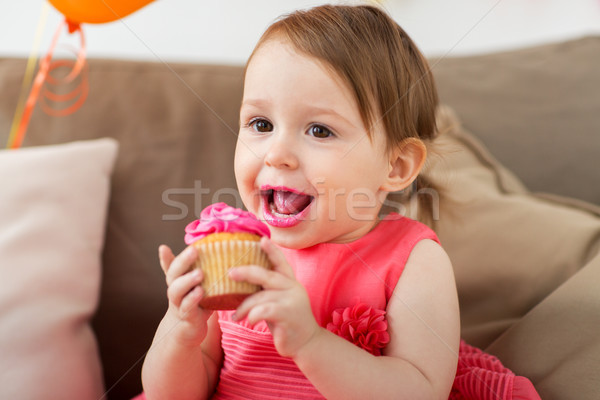 happy baby girl eating cupcake on birthday party Stock photo © dolgachov