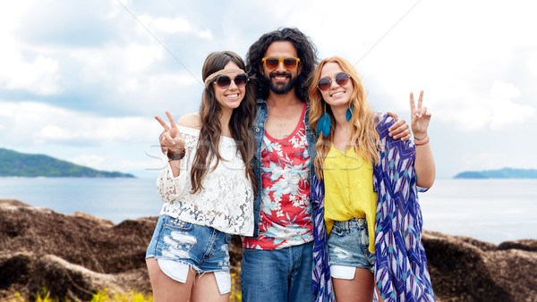 happy hippie friends showing peace on summer beach Stock photo © dolgachov