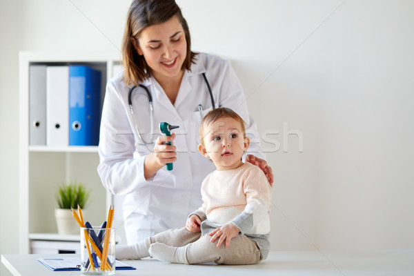 Stock photo: doctor with baby and otoscope at clinic