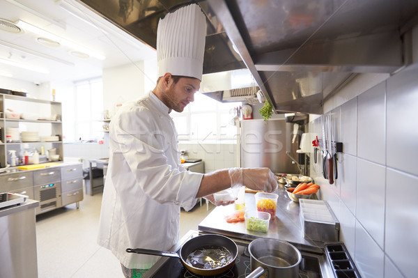 happy male chef cooking food at restaurant kitchen Stock photo © dolgachov