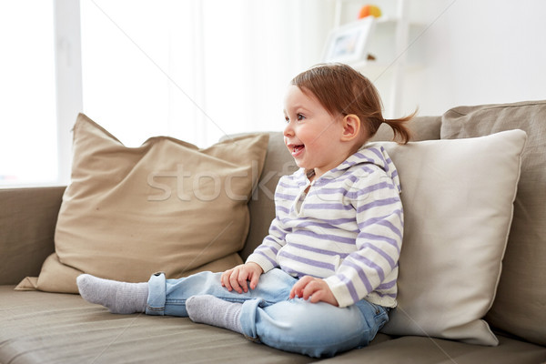 happy smiling baby girl sitting on sofa at home Stock photo © dolgachov