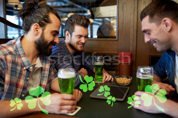 friends with tablet pc and green beer at pub Stock photo © dolgachov