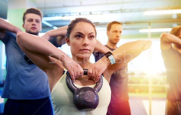 group of people with kettlebells exercising in gym Stock photo © dolgachov