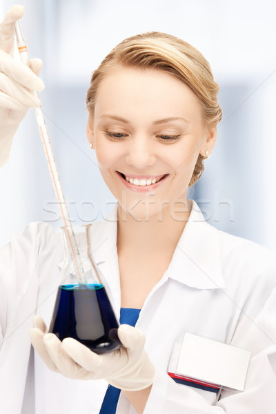 female chemist holding bulb with chemicals Stock photo © dolgachov