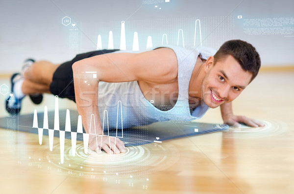smiling man doing push-ups in the gym Stock photo © dolgachov