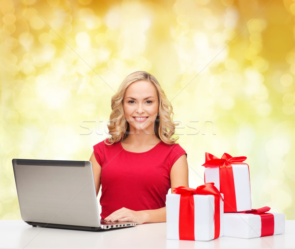 smiling woman in red shirt with gifts and laptop Stock photo © dolgachov