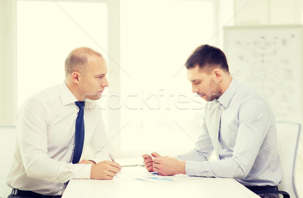 two serious businessman with papers in office Stock photo © dolgachov