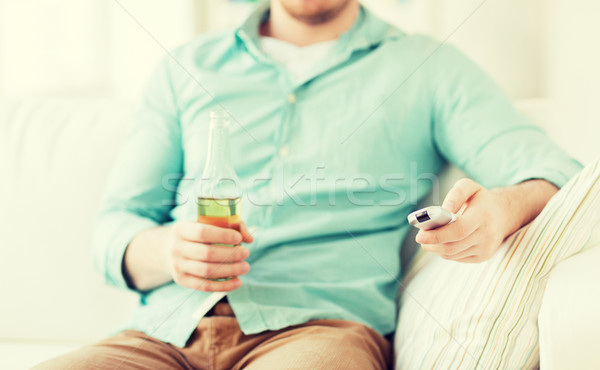 Stock photo: man with beer and remote control at home