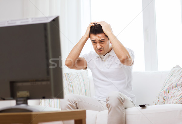 disappointed man watching tv at home Stock photo © dolgachov