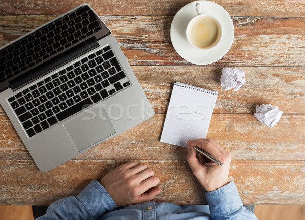 Stock photo: close up of male hands with laptop and notebook