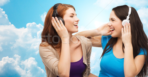 Dos feliz ninas auriculares escuchar música música Foto stock © dolgachov