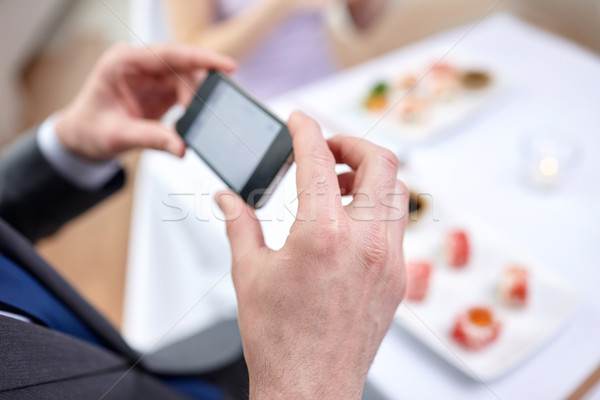 close up of couple with smartphones at restaurant Stock photo © dolgachov