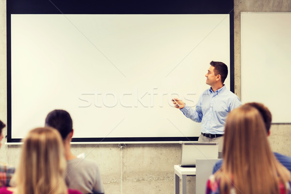 group of students and smiling teacher in classroom Stock photo © dolgachov