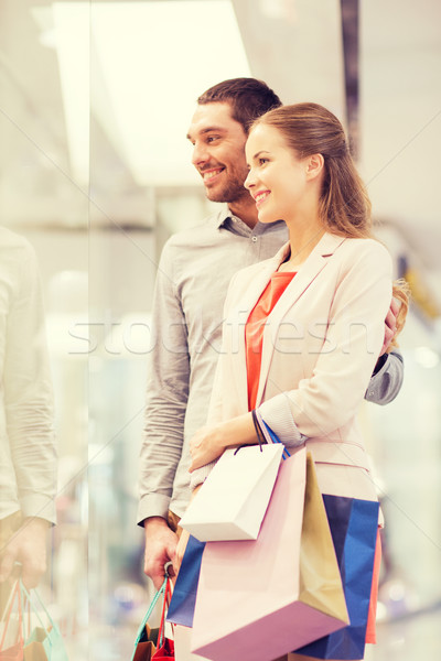 Stock photo: happy young couple with shopping bags in mall