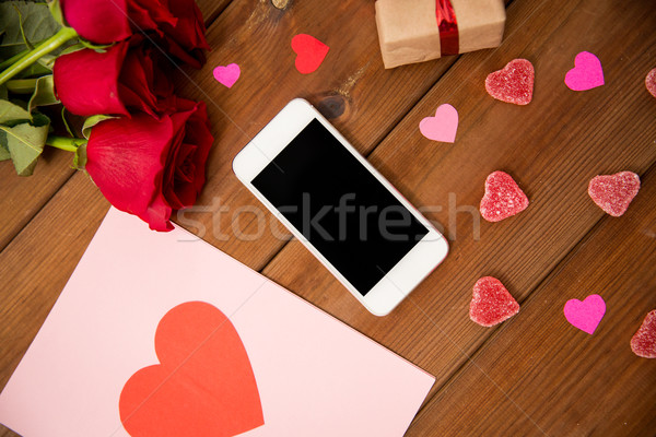 close up of smartphone, gift, red roses and hearts Stock photo © dolgachov