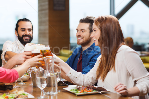 friends dining and drinking beer at restaurant Stock photo © dolgachov